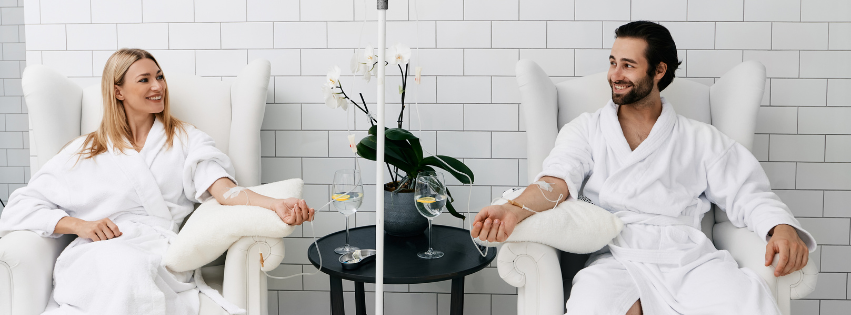 man and woman sitting down and receiving iv therapy